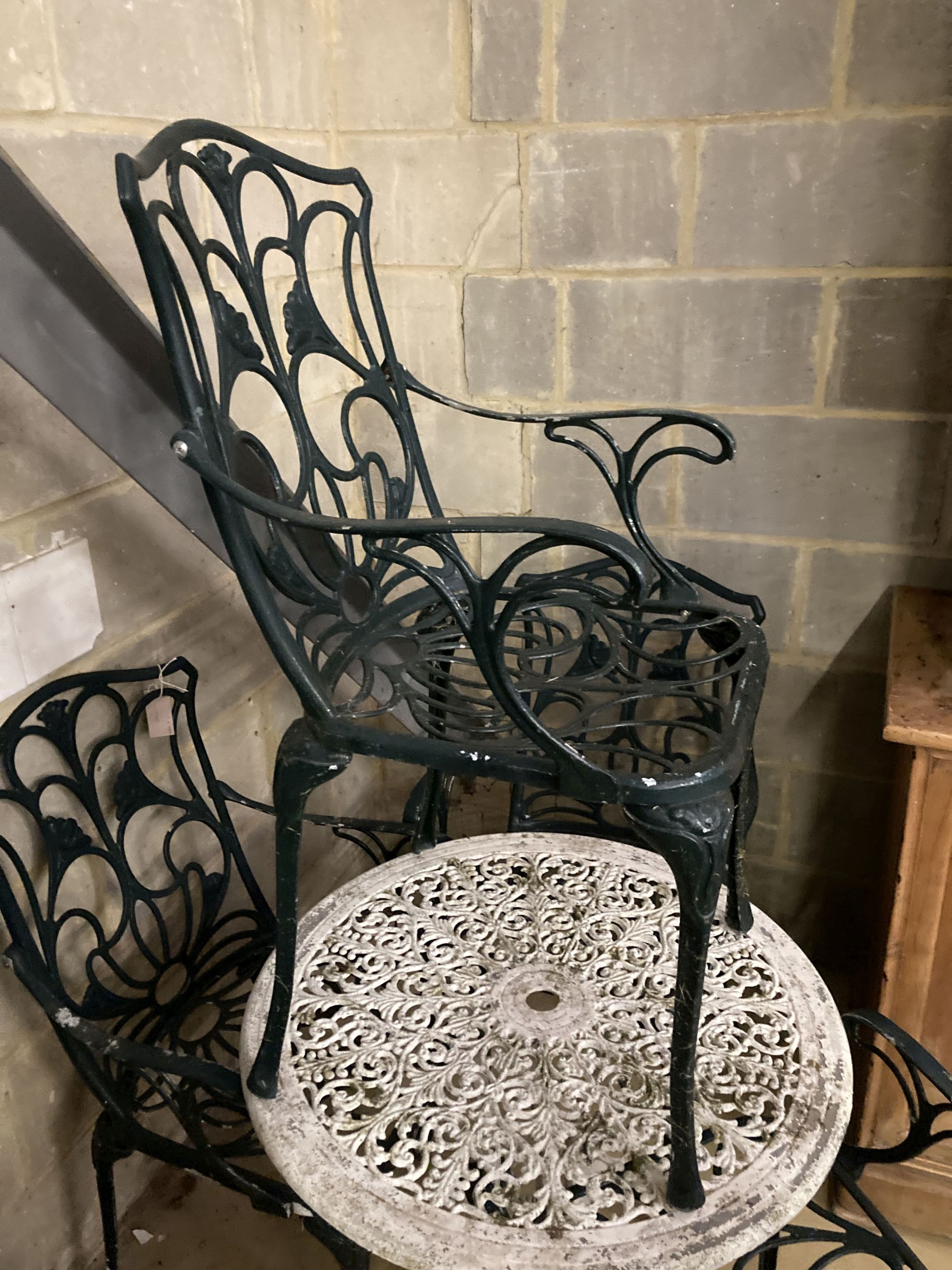 A Victorian style painted circular aluminium garden table, 68cm diameter together with a set of four painted aluminium garden elbow cha